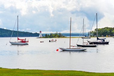 Boats and Kidston Island lighthouse on Bras D'Or lake, Cape Breton, Nova Scotia clipart