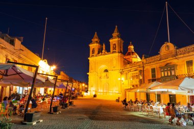 Marsaxlokk, Malta 'da popüler bir balıkçı kasabası olan Parish Kilisesi' nin oradaki meydanda fresk yiyoruz.