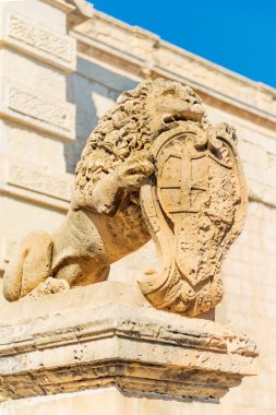 Lion statue with cote of arms by the main Vilhena Gate of ancient fortified Mdina, main landmark in the former capital of Malta clipart