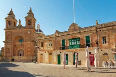 Malta 'nın popüler balıkçı köyü Marsaxlokk' taki kilise yakınlarındaki kasaba meydanındaki sokak restoranları ve kafeler.