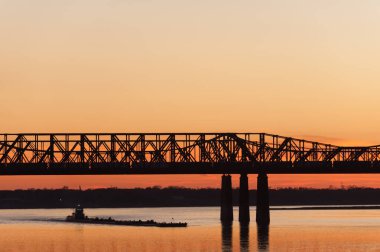 Memphis, Tennessee, ABD 'deki Şehitler Parkı' ndan Mississippi Nehri 'ne uzanan Harahan demiryolu ve yaya köprüsünün günbatımı manzarası