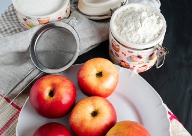 still life with apples spread out on a plate kitchen towel and flour artificial light