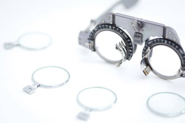 Göz testi çerçevesini beyaz arka planda göz koruması için farklı deneme lensleri olan gözlükçüler için kapat