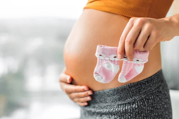 Zwangerschap Concept Zwangere Vrouw Tonen Schattig Roze Baby Sokken Als — Stockfoto