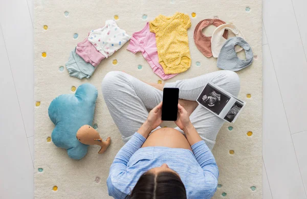 Mujer Embarazada Usando Aplicación Teléfono Para Compras Lectura Telemedicina Sobre Imagen de stock