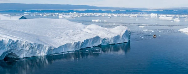 气候变化与全球变暖 格陵兰岛伊留利萨特冰川融化所产生的冰山 以及显示巨大规模的船只 受全球变暖影响的北极地区 可持续性概念 — 图库照片