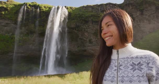 滝の屋外でアイスランドのセーターでアイスランドの女性の肖像画 観光名所と自然景観の中で候補美しい女性モデルSeljalandsfoss滝 — ストック動画