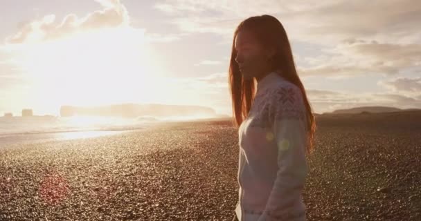 冰岛的场景 穿着传统的雪兰色毛衣的女人走在冰岛南部维克海岸附近的里尼斯法加拉黑色沙滩上 游览旅游胜地冰岛 享受午夜阳光 — 图库视频影像