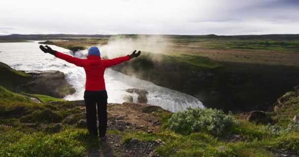在冰岛美丽的古尔佛斯瀑布前 快乐而宁静的探险女性与双臂伸出 享受着新鲜的空气和迷人的自然景观 冰岛著名的金圆上的旅游景点 — 图库视频影像