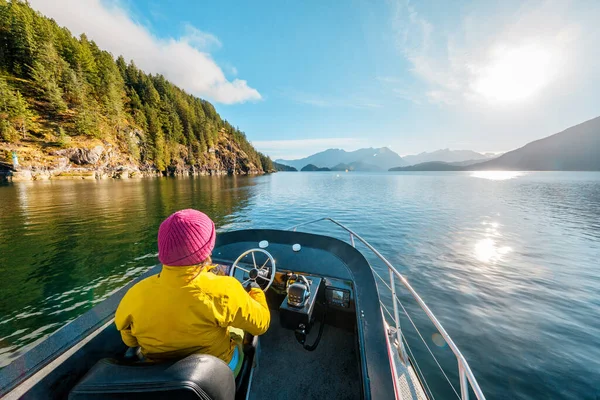 Woman Driving Motor Boat in Amazing Nature Landscape at Sunset in Coastal British Columbia Near Bute, Toba Inlet and Campbell River. Whale Watching Tourist Travel Destination, Canada.
