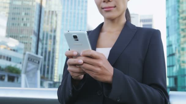 在城市商业区 女商人使用智能手机应用程序发送手机短信 年轻的女商人在户外用手机穿西装夹克 城市女性专业办公室工作人员 — 图库视频影像