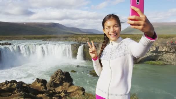 아이슬란드 관광객들은 폭포에서 스마트폰으로 사진을 관광지인 아이슬란드를 방문하는 아름다운 풍경을 — 비디오