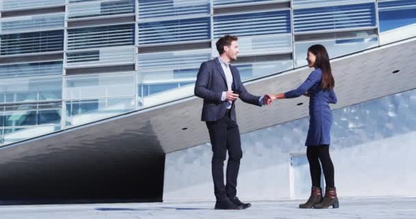 ビジネスの人々握手を満たす オフィスビルで屋外でビジネスマンとビジネス女性の間の握手 普段着 30代の若者 握手は終わりだ スローモーション — ストック動画