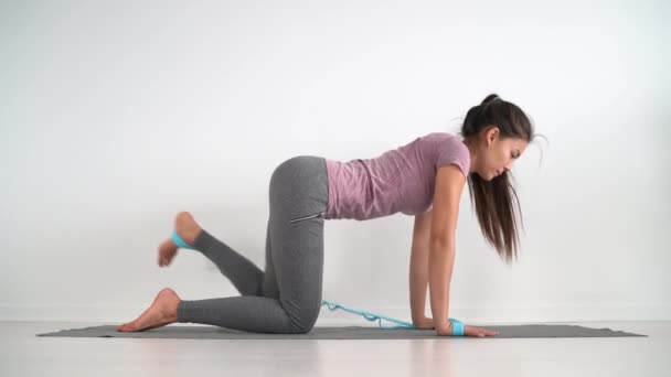 阻力带健身女孩用橡皮筋带弹性做腿锻炼驴踢地练习 带回扣的胶状肌肉活化 用于纤维素 — 图库视频影像