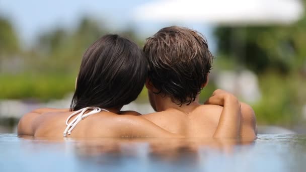 蜜月夫妇在豪华度假胜地温泉度假胜地的一个无限大游泳池里放松地在一起 豪华旅馆业度假 难以辨认的人放松地享受暑假 — 图库视频影像