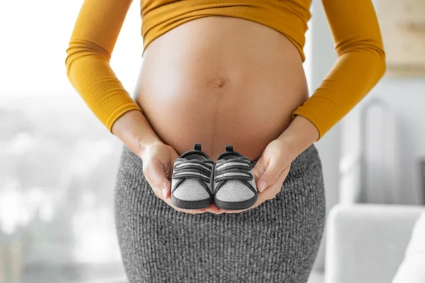 怀孕期间 怀孕的女性会看到男婴穿着深蓝色的鞋子 准妈妈表现出婴儿肚子痛 购买婴儿服装和性别揭示概念 — 图库照片
