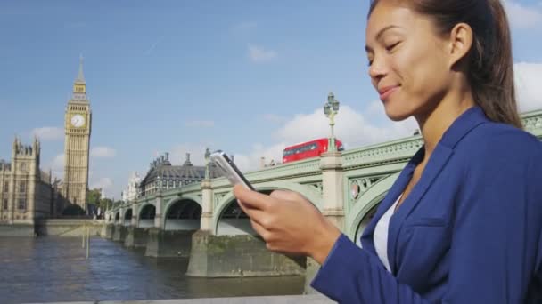 영국의 스마트폰 웨스터 브리지 사용하는 통화중이다 사업을 여성은 야외에서 행복하게 — 비디오