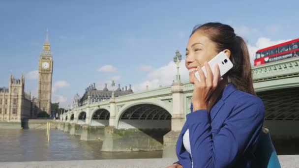 웨스터 브릿지에서 스마트폰으로 통화중입니다 사업가가 런던에서 전화로 대화를 나누는 아시아인 — 비디오