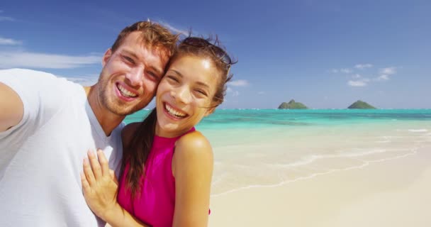 自拍视频 情侣在海滩度假用智能手机拍自拍 在美国夏威夷瓦胡岛的兰尼凯海滩 一对浪漫的情侣正在度蜜月 玩得很开心 红色Epic慢速运动 — 图库视频影像