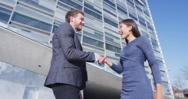 ビジネスの人々握手 ビジネスの人々握手 ビジネスビルで屋外のビジネスマンと女性の間の握手 カジュアルビジネス服30代の若者 スローモーション — ストック動画