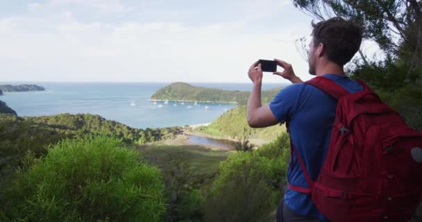 纽西兰游客用智能手机拍摄纽西兰阿贝尔塔斯曼国家公园的安克雷奇 男背包客在Abel Tasman海岸小道上徒步旅行慢动作 — 图库视频影像
