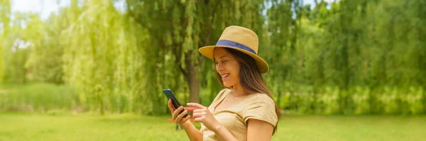女人在公园外面用电话程序看书 城市公园自然中快乐微笑的女士的画像 — 图库照片