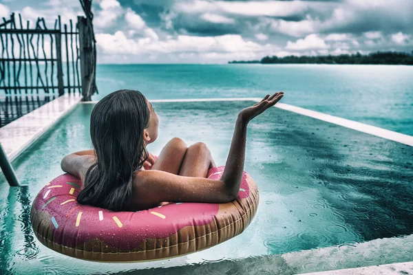 可悲的女人在阴雨天度假时 在加勒比的旅行度假时下了一场糟糕的假日雨 在游泳池里玩甜甜圈的女人很不高兴 — 图库照片