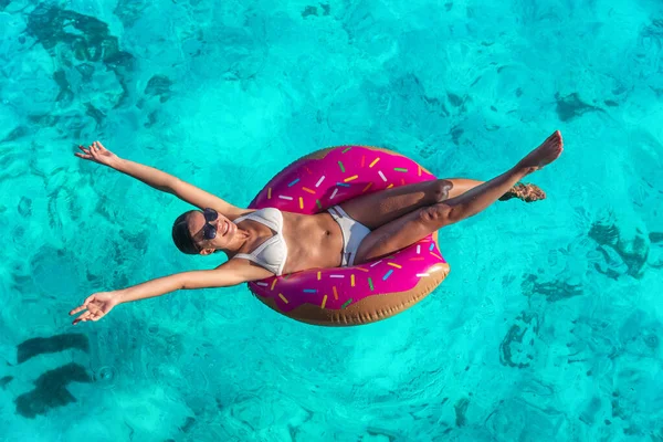 暑假快乐的女人在甜甜圈游泳池里放松 张开双臂 自由快乐地享受着蓝色大海背景的热带旅行 — 图库照片