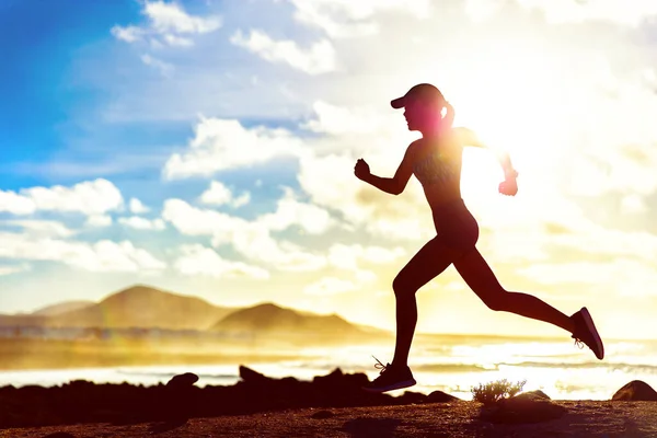 跑健美的女孩在日落时带着速度和动力跑过风景秀丽的海滩 夏季健美运动员赛跑运动员 适合身体轮廓室外训练心肺 — 图库照片