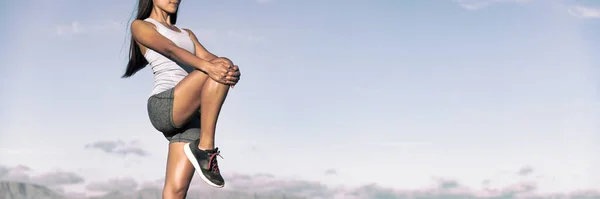 ランナーストレッチ足は 空の背景バナーパノラマで屋外に立って1本の足を保持筋肉の屋外をハムストリング 運動選手の女性がフィットネスストレッチを行う — ストック写真