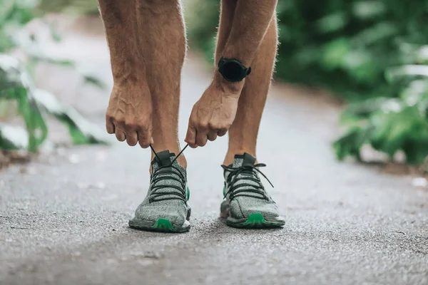 スマートウォッチ運動歩行スポーツマンは秋の自然の中でランニングシューズを履いて外の公園で実行する準備 — ストック写真