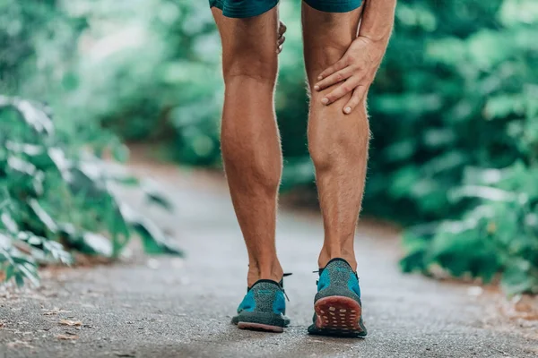 ランナーの足の怪我痛み足 痛みから屋外でトレーニングを実行している間に男は痛みのふくらはぎの筋肉をマッサージ — ストック写真