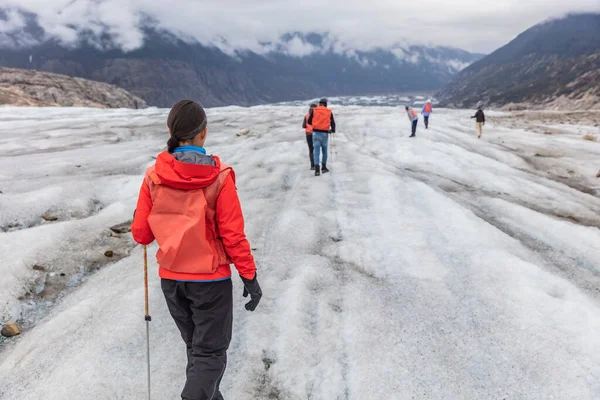 クルーズ船の遠足でアラスカ氷河のハイカーの女性 青い氷の冒険自然休暇でハイカーのグループと一緒に歩く観光の女の子 アラスカの休日で人気のある活動 — ストック写真