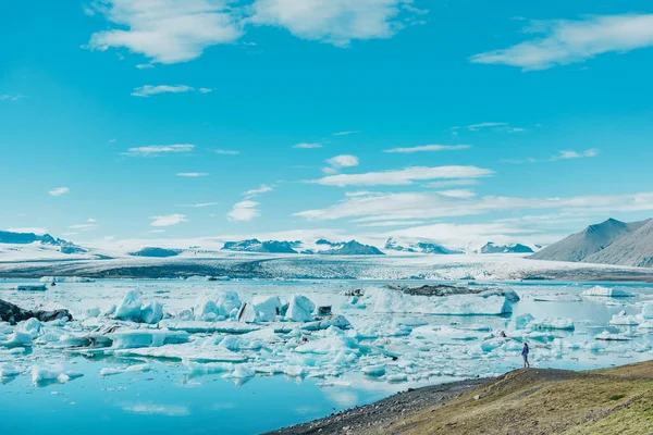 冰岛著名的旅游胜地 Jokulsarlon冰川景观与女徒步旅行者看冰山景观 冰冻的蓝色冰景全景 — 图库照片