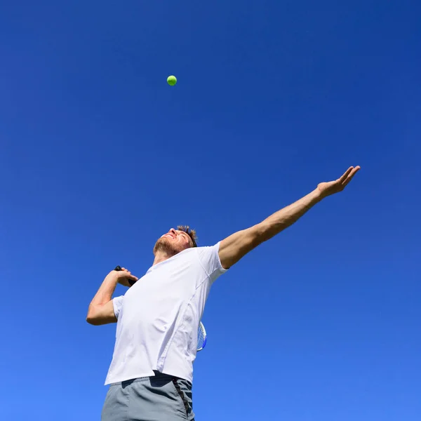 テニス選手の男は空気中のボールを打つための位置に機能します 青い空の夏の背景に屋外でテニスをする フィットネスの楽しさを行うアクティブなスポーツ選手 — ストック写真