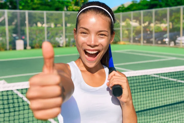 夏のクラスの屋外ブルーハードコートでラケットを保持ゲーム楽しい後 親指の手のサインを表示する幸せなアジアのテニスプレーヤーの女の子 満足感の笑みを浮かべてスポーツ民族の若い女性 — ストック写真
