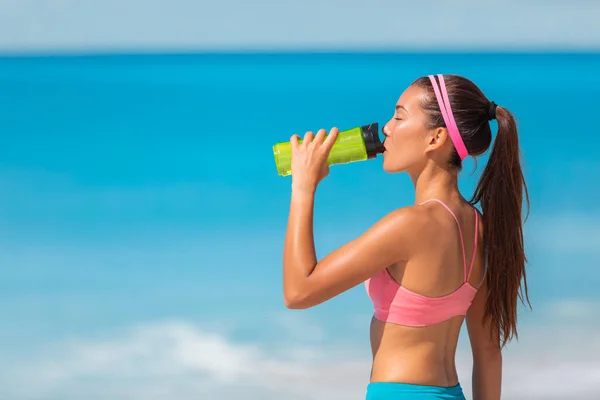 在室外海滩有氧运动中喝水瓶跑步者亚洲妇女在夏季热能饮料中出汗脱水 — 图库照片
