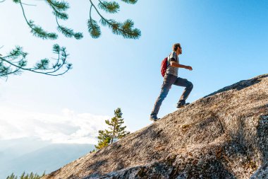 Challenges, success and accomplishment in business and life. Aspirational conceptual image of fit male hiker man climbing and hiking steep mountain in uphill climb. clipart