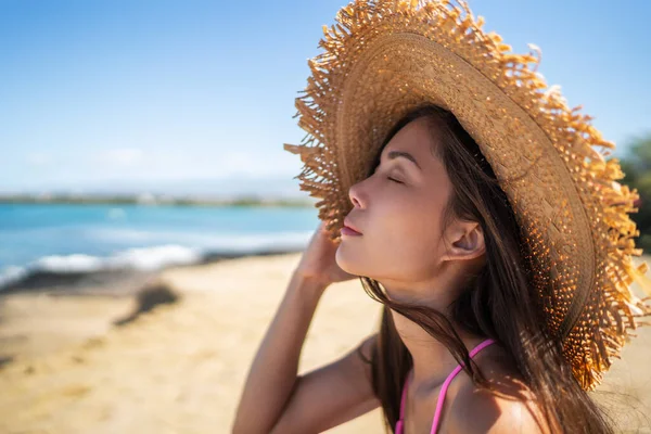 禅のウェルネスで新鮮な空気呼吸を楽しむ目を閉じて幸せなビーチの女性 カリブ海の休日の休暇で夏の旅行を楽しんで太陽の帽子をかぶっているアジアの女の子 — ストック写真