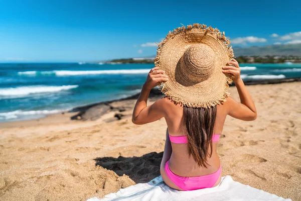 ビーチガールでピンクビキニを身に着けていますフロッピー帽子サンタニングオンカリブ海の目的地でのビーチの休日日光浴海の景色とリラックス ストック写真