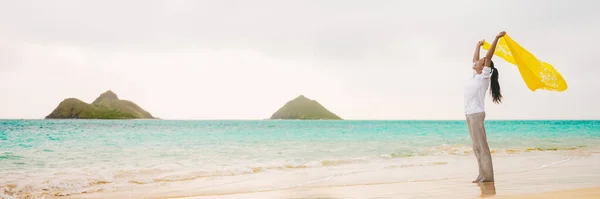 행복의 자유를 누리는 하와이 해변의 전경을 배경으로 스카프를 흔들고 있습니다 스톡 사진