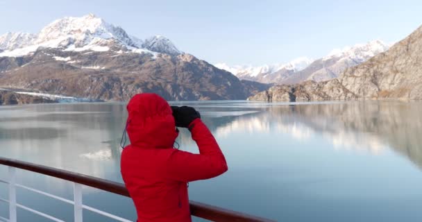 アラスカ氷河湾クルーズ船の乗客は 米国の氷河湾国立公園を探索双眼鏡でアラスカの山々を見ています 女性の旅パス内の景色を楽しむ 休暇の冒険 — ストック動画
