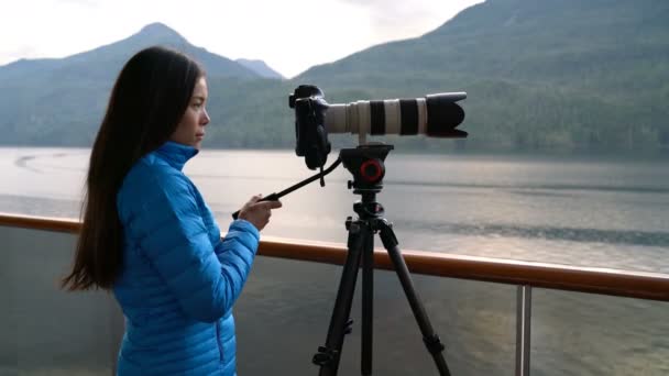 在美国阿拉斯加州拍摄野生动物的三脚架上 旅行摄影师用专业的心灵感应镜头相机拍摄野生动物 在通道内游览风景游轮游客度假之旅 拍照的女人 — 图库视频影像