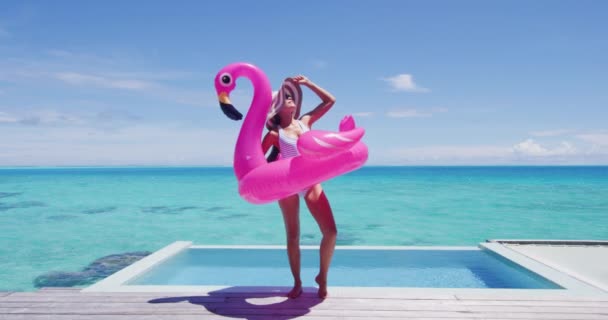 비키니를 수영장에서 분홍색 플라밍고가 떠다니는 수영장 장난감 매트리스를 가지고 아가씨가 — 비디오