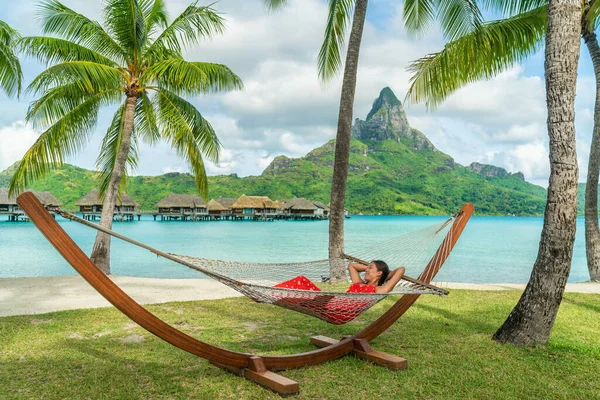 豪華なリゾートビーチの休日の女性は タヒチ フランス領ポリネシアのホテルの水上バンガローによってハンモックに横たわってリラックスしています 幸せな夏休み休暇 — ストック写真