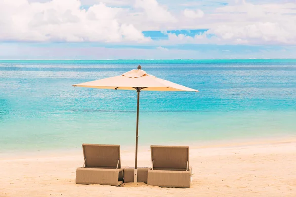 ビーチラグジュアリーリゾート熱帯の休暇カリブ海の目的地 青い海の水の楽園の休暇の背景に太陽の傘を持つ2つのラウンジャーチェア — ストック写真