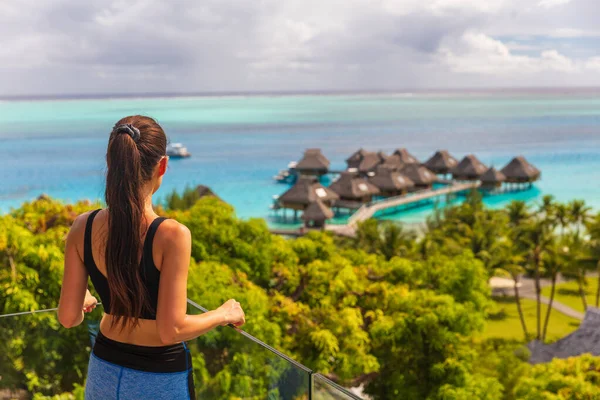豪華なボラボラホテルのリゾート女性観光客がタヒチ島の海 フランス領ポリネシアの水上バンガローヴィラの景色を見下ろす — ストック写真