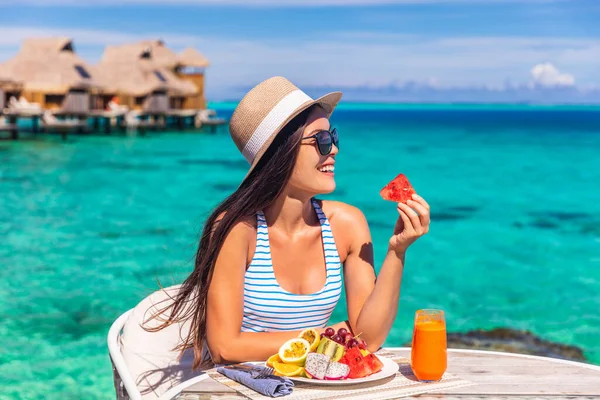 高級リゾート休暇の女性は プライベートテラス付きのビーチホテルの部屋でフルーツデトックス朝食を食べています 観光の女の子の健康的な食生活 — ストック写真