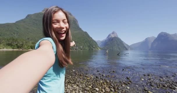 在纽西兰旅行时自拍视频的女人叫Milford Sound快乐的女孩带着坦率的自画像视频旅行 新西兰 Fiordland 慢动作 — 图库视频影像