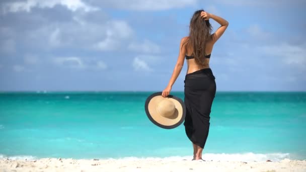 身穿黑色比基尼和沙隆的女人站在海滩上 优雅性感的女性穿着黑色比基尼和沙隆在海滩上 在加勒比地区的度假胜地 妇女们正在尽情享受暑假 — 图库视频影像